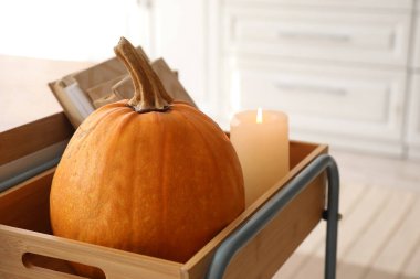 Balkabaklı çekmece, yanan mum ve mutfakta kitap, yakın plan.