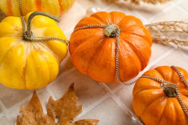 Bej kaplama arka planda düşmüş yapraklı Cadılar Bayramı balkabakları, yakın plan