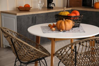 Modern mutfakta yemek masasında Cadılar Bayramı balkabağı dolu sepet.