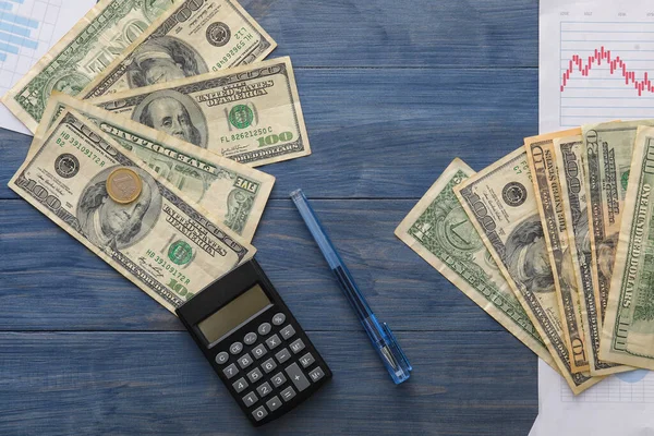 Долларовые Банкноты Монетами Калькулятором Ручкой Диаграммами Синем Деревянном Фоне Концепция — стоковое фото