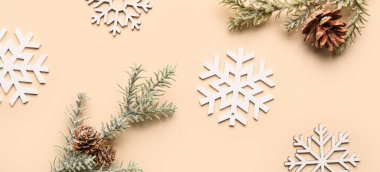 Kar taneleri, köknar dalları ve bej arka planda koniler, üst görünüm