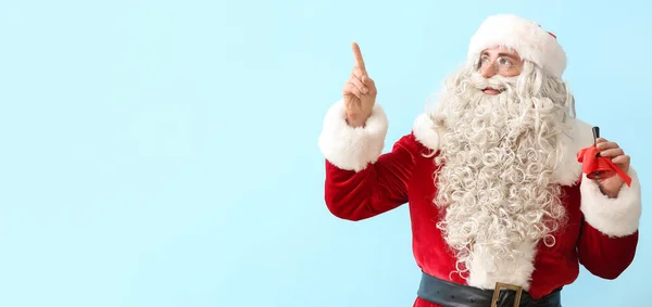 Santa Claus Con Campana Navidad Apuntando Algo Sobre Fondo Azul — Foto de Stock