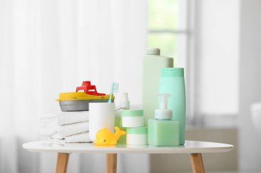 Çocuklar için farklı banyo aksesuarları ve aydınlatma odasındaki masada duran oyuncaklar.