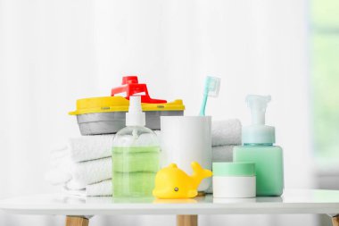 Çocuklar için farklı banyo aksesuarları ve aydınlatma odasındaki masada duran oyuncaklar.