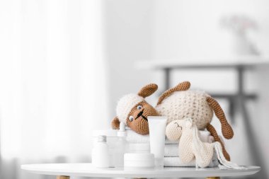 Çocuklar için farklı banyo aksesuarları ve hafif banyodaki masada sevimli oyuncaklar.