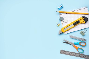 Mavi arka planda kırtasiye malzemesi olan bir araç bıçağı.