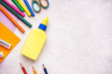 Hafif arkaplanda bir şişe yapıştırıcı ve kırtasiye malzemesi