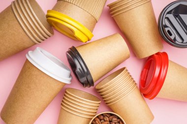 Pembe arka planda farklı kağıt bardaklar, yakın plan