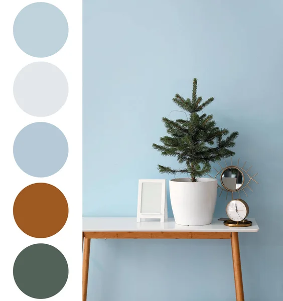 小さなクリスマスツリー 空白の写真フレームとライトブルーの壁の近くの目覚まし時計とテーブル 異なる色パターン — ストック写真