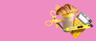 Uçan kağıt kahve fincanı ve pembe arka planda okul malzemeleri.