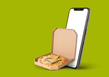 Yeşil arka planda akıllı telefon ve pizza kutusu. Yemek teslimatı