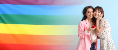 Genç nişanlı lezbiyen çift ve LGBT bayrağı