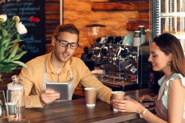 Kafelerinde tablet bilgisayarı ve kahve bardakları olan genç işletme sahipleri.