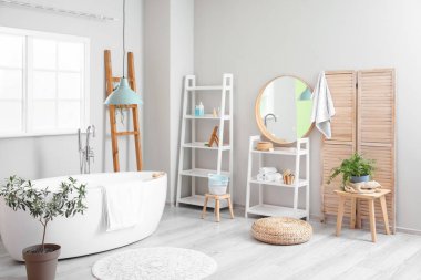 Rafları, merdiveni ve aynası olan hafif banyonun içi.