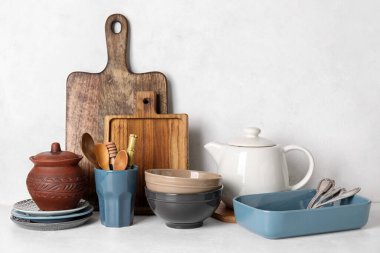 Beyaz masada farklı bulaşık takımları ve mutfak malzemeleri.