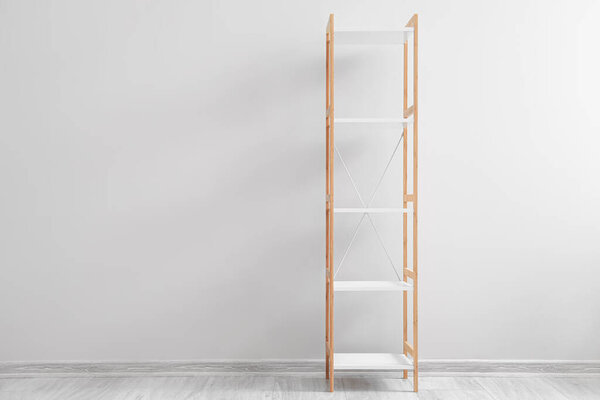 Empty wooden shelving unit near light wall in room
