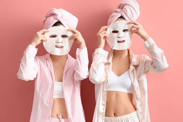 Mooie Jonge Vrouwen Pyjama Met Gezichtsmaskers Roze Achtergrond — Stockfoto