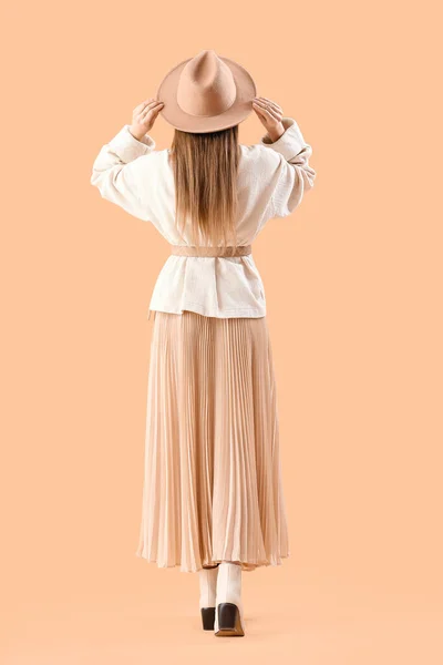 スカート ニットセーターで美しいファッショナブルな若い女性ベージュの背景 バックビュー — ストック写真