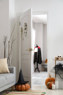 Açık kapısı ve cadılar bayramı dekoru olan modern oturma odası.