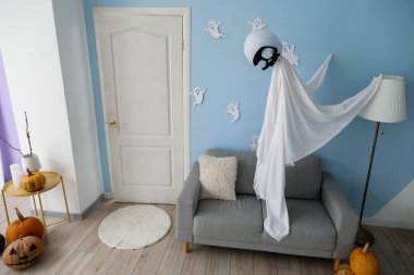 Kanepesi ve Cadılar Bayramı dekoru olan şık bir oturma odası.