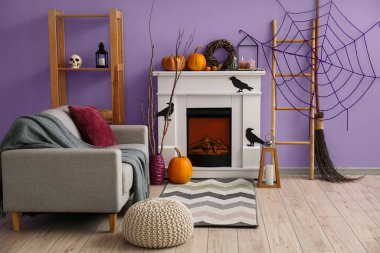 Cadılar Bayramı için şömine ve kanepeyle dekore edilmiş oturma odasının içi.