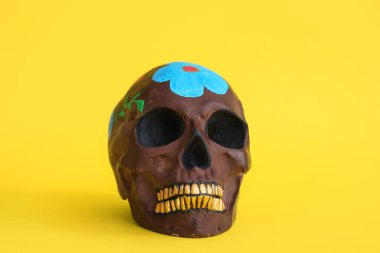 Sarı arka planda Meksika Ölüler Günü (El Dia de Muertos) için boyanmış kafatası