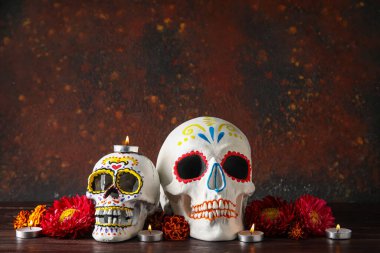 Meksika Ölüler Günü (El Dia de Muertos) için boyalı kafatasları ve arkaplanda çiçekler
