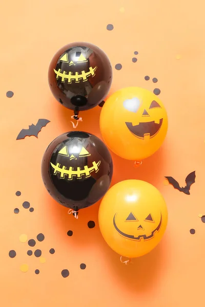 Funny balloons for Halloween party on color background