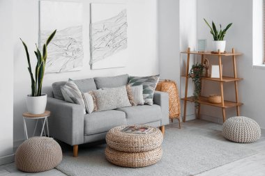Kanepe, puf ve 3 boyutlu tekstil sanat eserleriyle modern oturma odasının içinde.