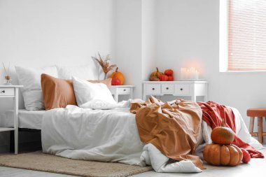 Balkabaklı, yanan mumlu, rahat bir yatak odası.