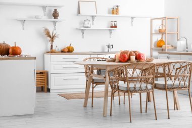 Kabaklı yemek masası, otlu otlar ve hafif mutfakta yanan mumlar.