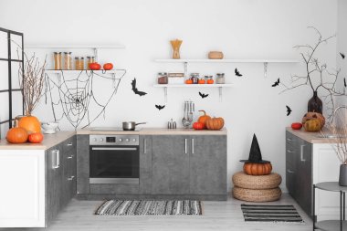 Cadılar Bayramı 'nda balkabakları ve siyah tezgahlarla dekore edilmiş modern mutfağın içi.