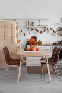 Cadılar Bayramı 'nda yemek masası ve tezgahlarla dekore edilmiş hafif mutfak.