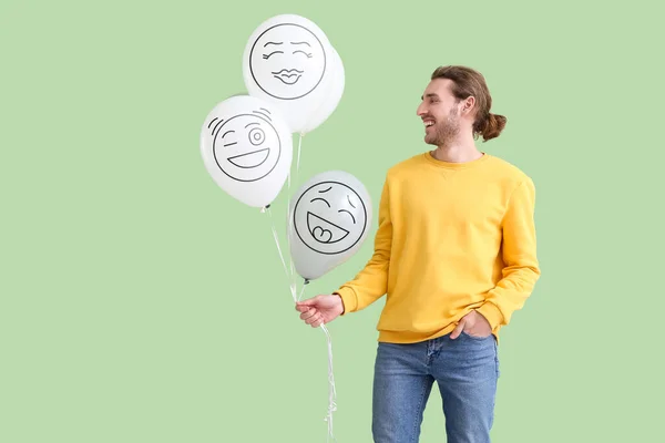 Happy Young Man Holding Balloons Drawn Emoticons Green Background — Stock Photo, Image