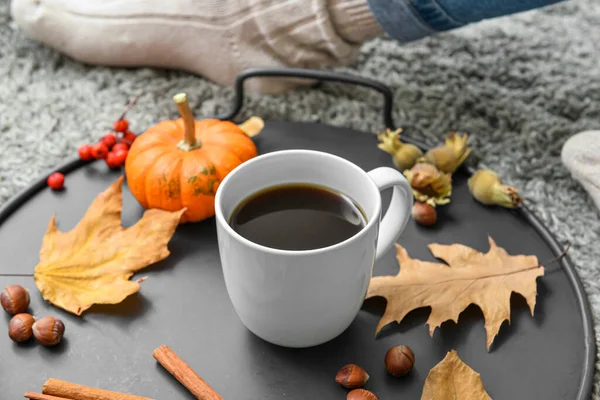 Tray with cup of delicious pumpkin coffee and autumn decor on soft plaid