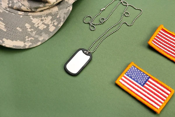 Military cap, tag and chevrons of USA army on green background, closeup