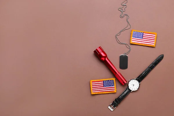 Chevrons of USA army, military tag, wristwatch and flashlight on color background