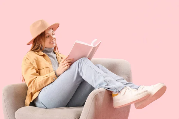 Jonge Vrouw Lezen Boek Fauteuil Roze Achtergrond — Stockfoto