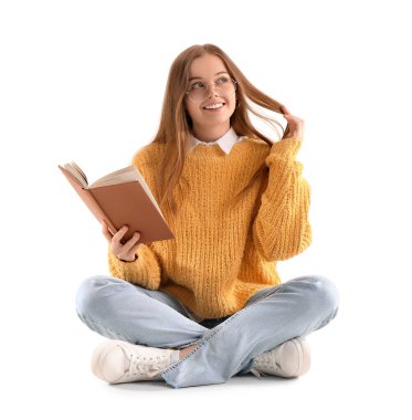 Beyaz arka planda oturan sarı kazaklı genç bir kadın.