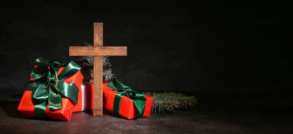 クロスとテキストのためのスペースで暗い背景に贈り物 クリスマスストーリーの概念 — ストック写真