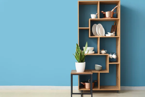 Wooden Shelving Unit Dinnerware Table Houseplant Blue Wall — Stock Photo, Image