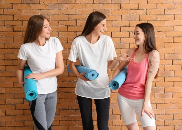 Sportliche Junge Frauen Mit Yogamatten Nahe Ziegelmauer — Stockfoto