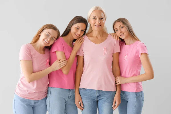 Mooie Vrouwen Met Roze Bewustzijn Linten Knuffelen Lichte Achtergrond Borstkankerconcept — Stockfoto