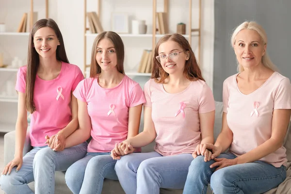 ピンクの意識のリボンを持つ美しい女性は自宅でソファに手を握っています 乳がんの概念 — ストック写真