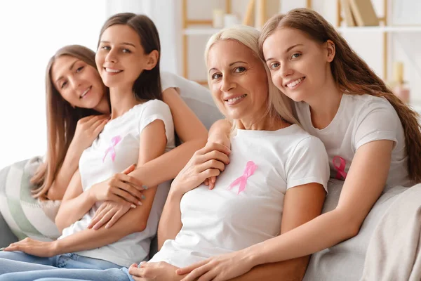 Hermosas Mujeres Con Cintas Conciencia Rosa Abrazándose Sofá Casa Concepto — Foto de Stock