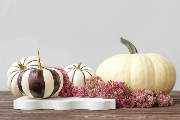 Sammansättning Med Målade Halloween Pumpor Och Blommor Träbord Nära Ljusvägg — Stockfoto