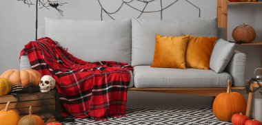 Oturma odasında cadılar bayramı için dekore edilmiş gri bir kanepe.