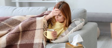 Hasta kadın evde sıcak çay içiyor.