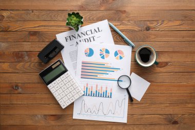 İş çizelgeleri, bir fincan kahve ve ahşap arka planda kırtasiye.