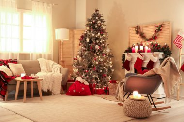 Oturma odasının içinde Noel ağacı, kanepe ve koltuk var.